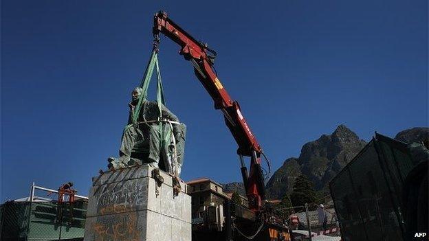 A picture taken on 9 April, 2015 shows the statue of British colonialist Cecil Rhodes being tied by straps to a crane, before its removal at the University of Cape Town. South Africa's oldest university voted on 8 April to remove the monument from its campus after a month of student protests against a perceived symbol of historical white oppression.