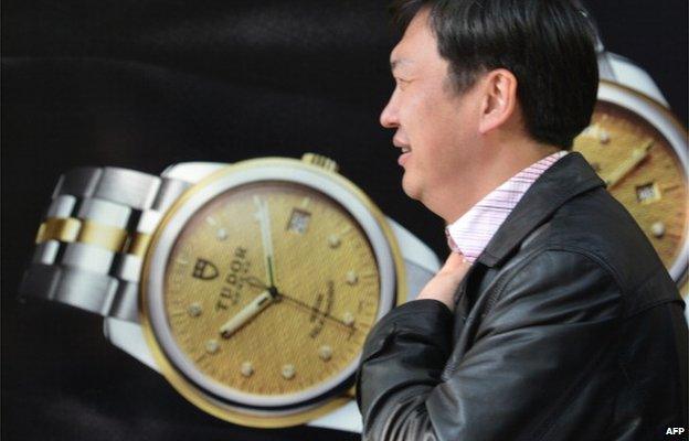 A pedestrian walks past a luxury watch shop in a major shopping district in Shanghai on 19 December 2013.