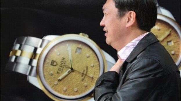 A pedestrian walks past a luxury watch shop in a major shopping district in Shanghai on 19 December 2013.