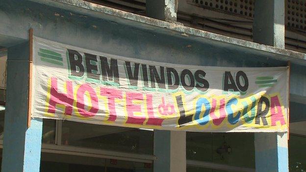 A banner hangs above a doorway with 'Welcome to the Madness Hotel' in Portuguese