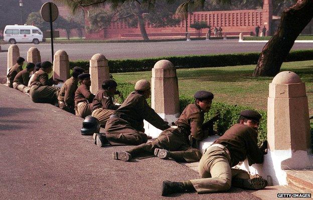 Delhi police commandos take cover outside the Indian parliament buildings on 13 December, 2001 in New Delhi, India. A group of armed men opened fire in India's parliament complex, killing several people in an unprecedented attack on the seat of government in the world's largest democracy.