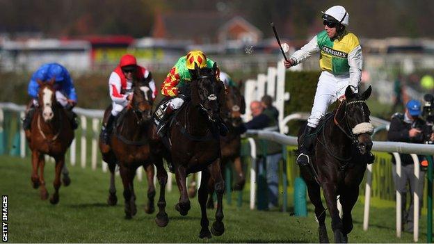 Liam Treadwell (red and white livery) brings Monbeg Dude home in third place at the 2015 Grand National behind Many Clouds and Saint Are