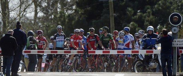 Riders wait at a level crossing