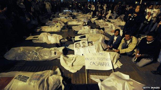 People demonstrate by covering themselves with sheets pretending they are false positive victims, during a protest against the false positives, massacres and forced disappearances by Colombian authorities on March 6, 2009, in Bogota.