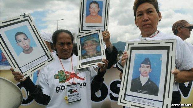 Relatives hold pictures of their beloved during a march against the false positives, massacres and forced disappearances by Colombian authorities on March 6, 2009, in Bogota.