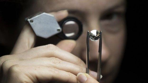 A jeweller scrutinises a diamond