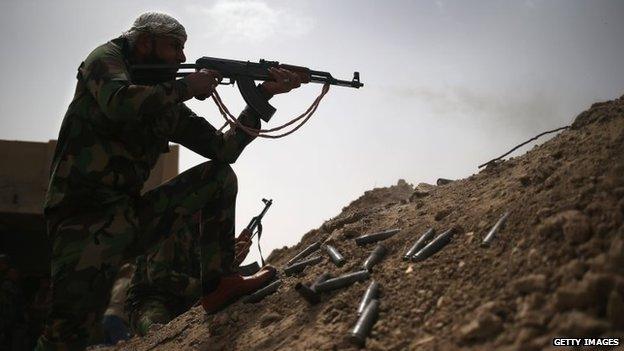 Shia militiamen takes aim at Islamic State militants on the frontline in Ibrahim Ben Ali, in Anbar province, Iraq (11 April 2015)