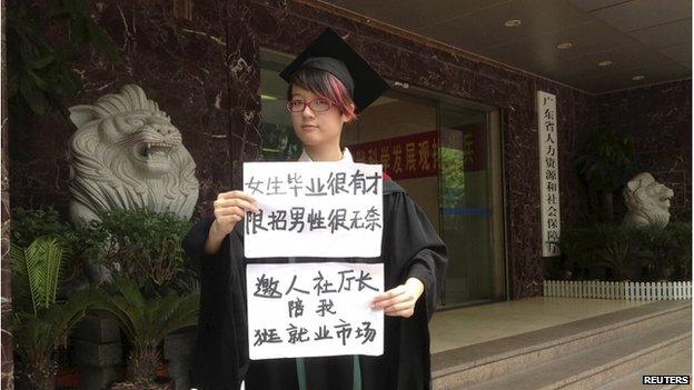 Women activist Zheng Churan, 25, poses for a photograph with papers which read "Women graduates are talented, only hiring men is frustrating" (top) and "I invite the head of Human Resources and Social Security department to go to the job market with me", in this undated file handout picture taken in an unknown location in China, provided by a women's rights group on 8 April 2015.