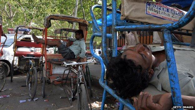 Indian rickshaw pullers sleep during the heat of the day in New Delhi on 10 June, 2014