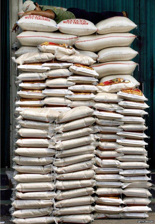A labourer takes a nap on top of rice-sacks at a market in Jakarta, Indonesia, 5 September 2006