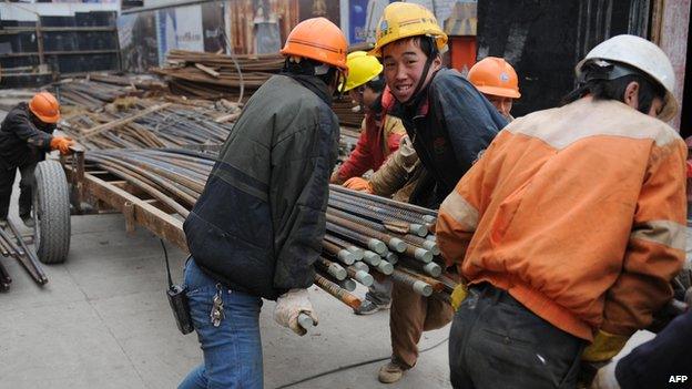 Chinese construction workers prepare steel reinforcing rods at a building site in Shanghai, 17 January 2008