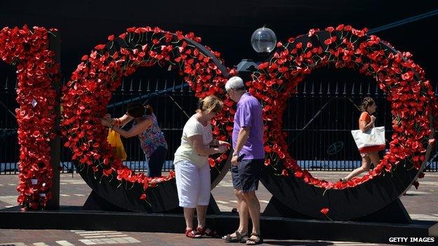 Visitors pay respects to Australia's Anzac soldiers as they pin a poppy to Wall of Remembrance in front of Queen Elizabeth cruise ship in Sydney on 3 March 2015