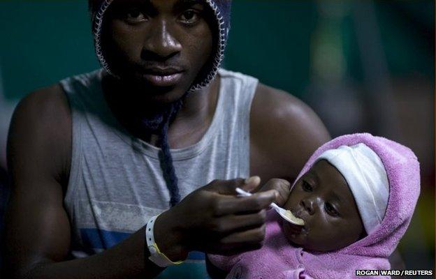 A man feeds his young child in Isipingo, south of Durban