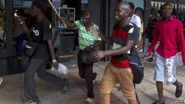 South African men run from police as rioting and looting was quelled during anti-foreigner violence in Durban 14 April 2015