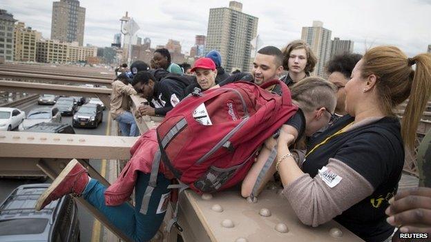 People climb on the Brooklyn Bridge 14 April 2015