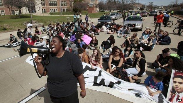 T Banks of Madison, a 2006 graduate of Madison East High School, leads a chant during a sit-in protest in front of the high school on East Washington Avenue in Madison, Wisconsin, 14 April 2015