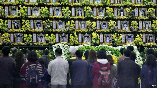 People pay a tribute at a group memorial altar for the victims of the sunken South Korean ferry Sewol at a remembrance hall in Ansan on 16 April 2015