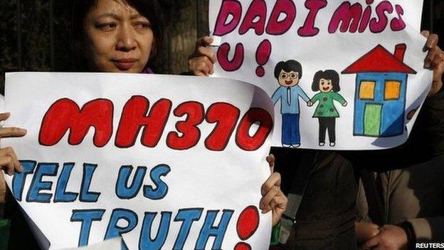 Catherine Gang, whose husband Li Zhi was on board the missing Malaysia Airlines flight MH370, holds a sign during a gathering of family members of the missing passengers outside the Malaysian embassy in Beijing, China, 8 March 2015