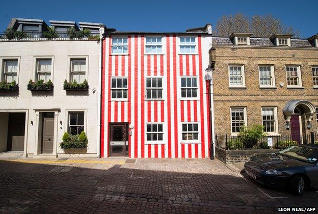 A house stands painted in red and white stripes in Kensington, London