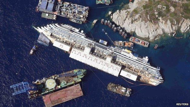 An aerial view shows the Costa Concordia as it lies on its side next to Giglio Island taken from an Italian navy helicopter - August 26, 2013