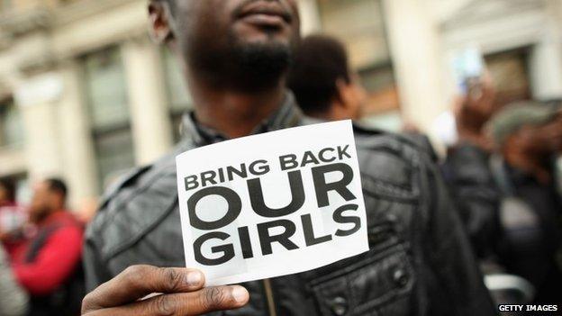 Man holds sign saying Bring Back Our Girls, outside Nigeria House in London