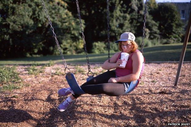 Photo of girl on swing drinking through straw