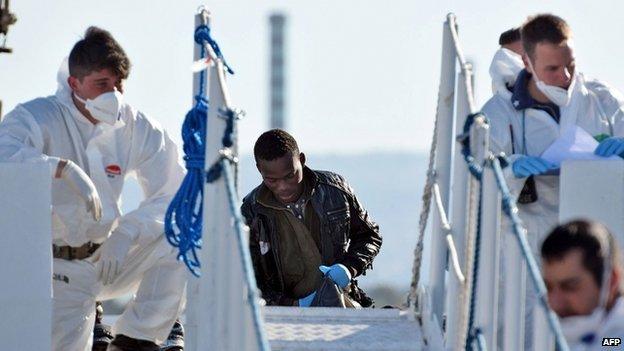 Italian Red Cross personnel prepare to give first aid to shipwrecked migrants as they arrive in the Italian port of Augusta in Sicily on 16 April 2015.