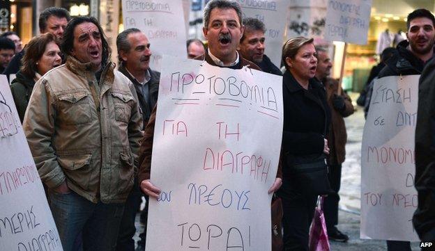 Public sector worker with placard reading "Initiative for writing off the debt now" - 9 April