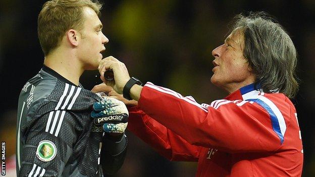 Hans-Wilhelm Mueller-Wohlfahrt treating goalkeeper Manuel Neuer