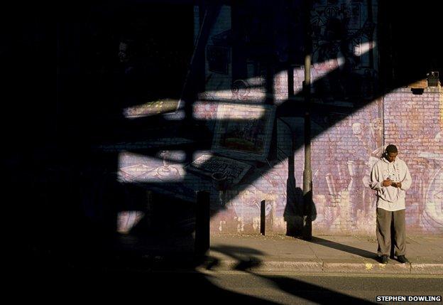 Stephen Dowling's photo of man against wall listening to music through headphones