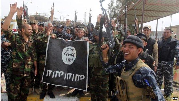 Iraqi security forces and members of the Popular Mobilisation hold an Islamic State emblem in Tikrit (01/04/15)