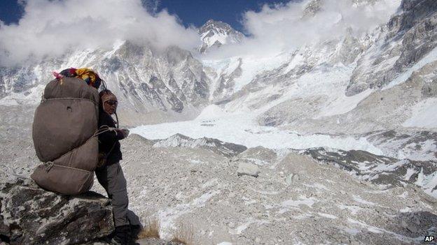 A porter rests carrying supplies for the upcoming climbing season, near the Everest Base camp, Nepal