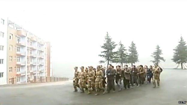 Officials in the Chinese county of Qianxi marching in a military-style remedial training camp.