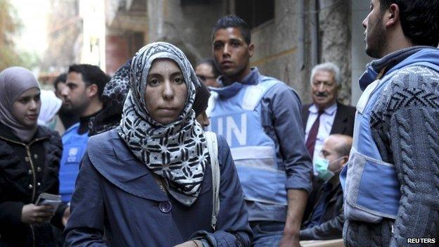 Women collect food aid distributed by United Nations Relief and Works Agency (UNRWA) at the Yarmouk refugee camp in this March 10, 2015