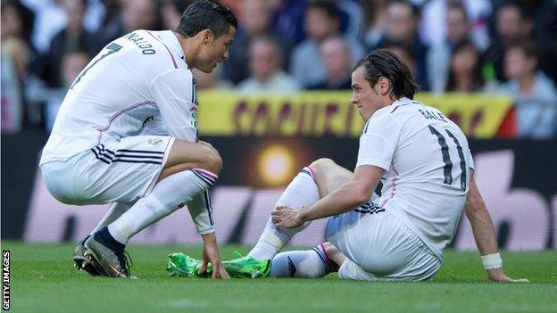 Concerned Real Madrid team-mate Cristiano Ronaldo checks on Gareth Bale's injury