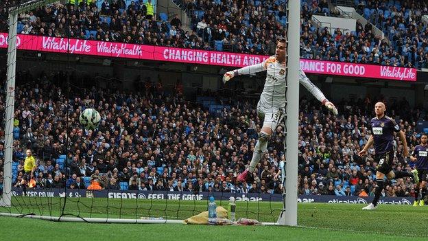 West Ham defender James Collins watches on as his clearance loops over keeper Adrian to give Man City the lead