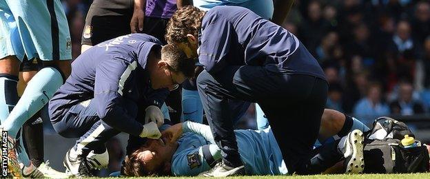 Man City's David Silva receives treatment before being taken off on a stretcher