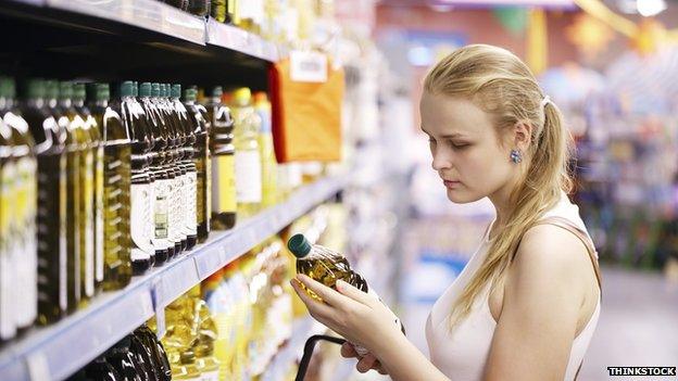 Woman checking price of cooking oil