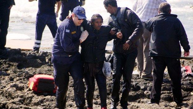 Greek coast guards help a migrant woman rescued after a boat carrying migrants sank off the island of Rhodes, southeastern Greece, on 20 April