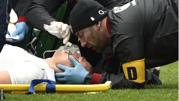 Mike Brown is tended to by medics after being knocked unconscious in England's game with Italy