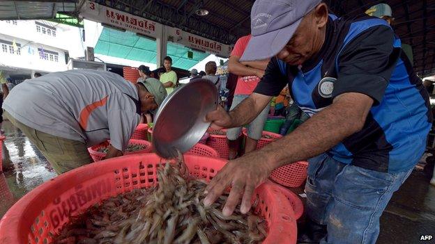 Workers weigh prawns at a market in Samut Sakhon province, a suburb of Bangkok, on 22 October 2014