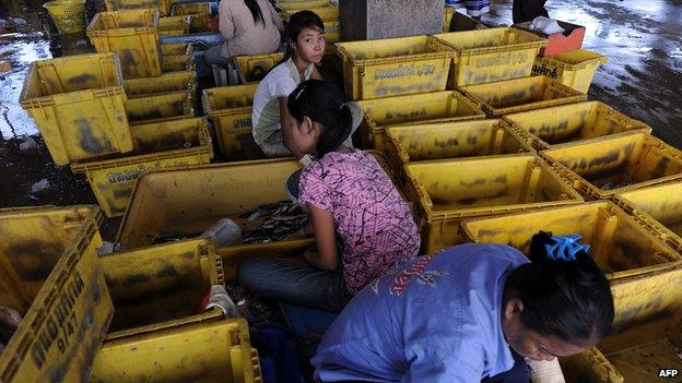 Labourers sorting fish unloaded from a trawler at a port in Pattani, southern Thailand