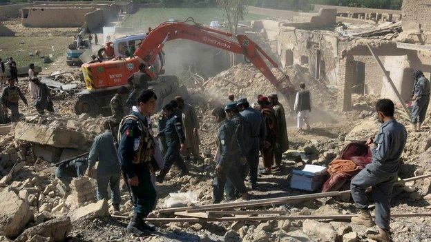 Afghan security forces inspect the site of a bomb blast in Kandahar