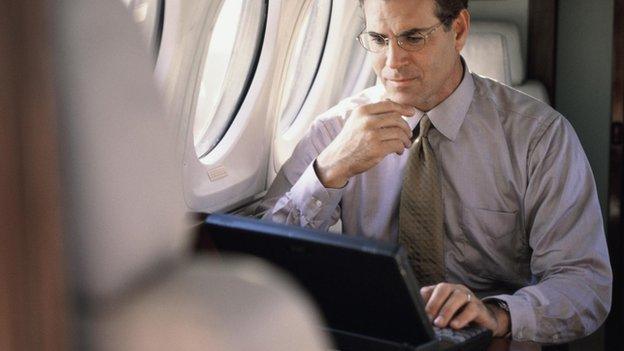 Man using laptop on a plane