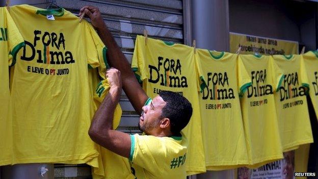 A vendor hangs shirts reading "Out, Dilma" during a protest against Brazil's President Dilma Rousseff in Sao Paulo on 12 April, 2015.