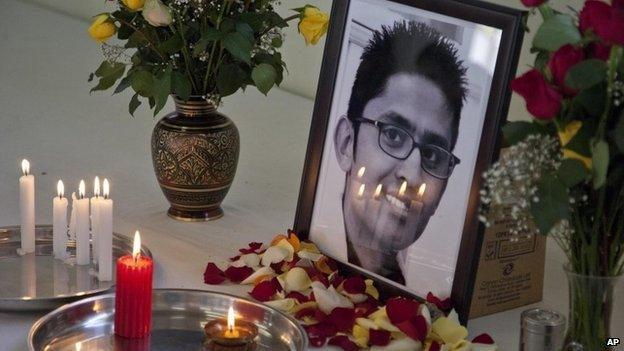 Candles reflect on the photo of late 24-year old Rajan Lalitkumar Solanki, during a prayers ceremony at Arya Samaj Temple in Nairobi, Kenya, Sunday, 29 September 2013