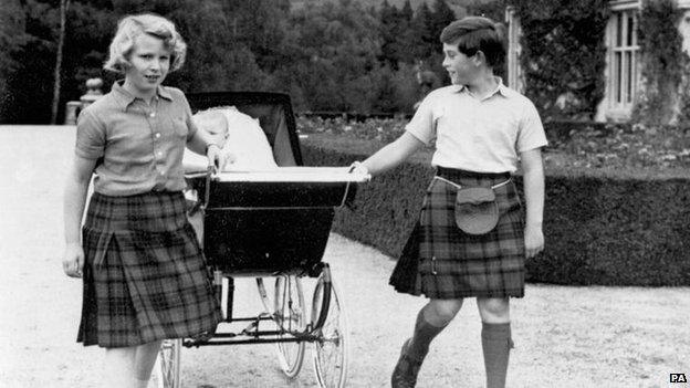 Prince Charles and Princess Anne pull a pram containing their baby brother Prince Andrew