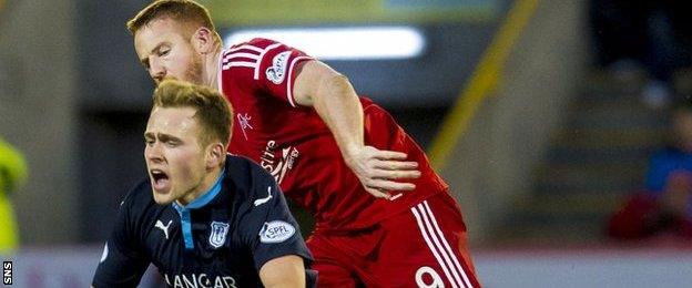 Dundee's Greg Stewart is challenged by Adam Rooney of Aberdeen