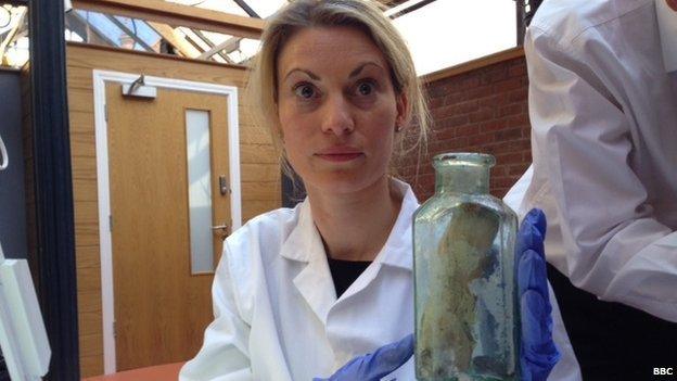 Conservator Stefanie White with bottle which was inside the time capsule