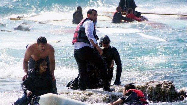 Local residents and rescue workers help a migrant woman after a boat carrying migrants sank off the island of Rhodes, southeastern Greece, 20 April 2015